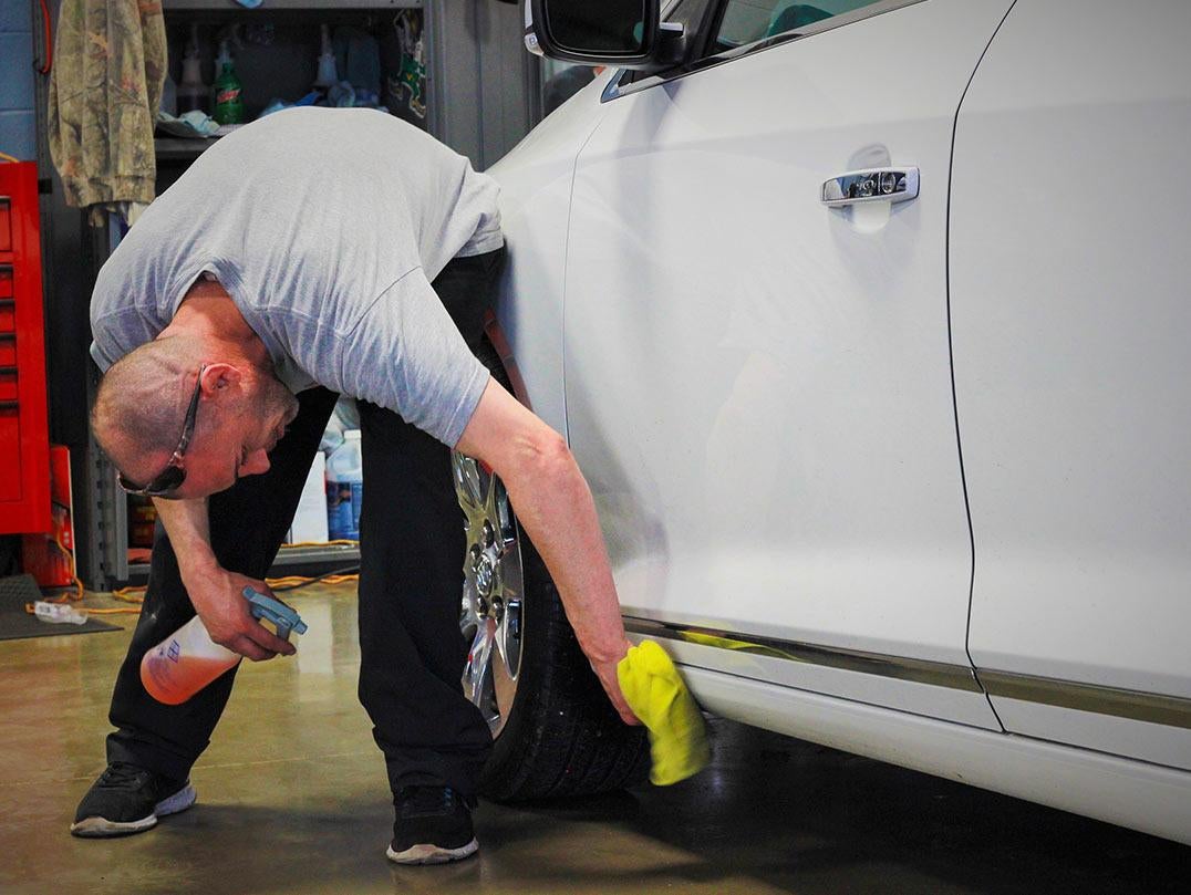 image of a man wiping a car