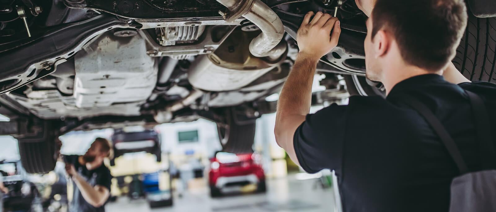 image of a mechanic working under a car